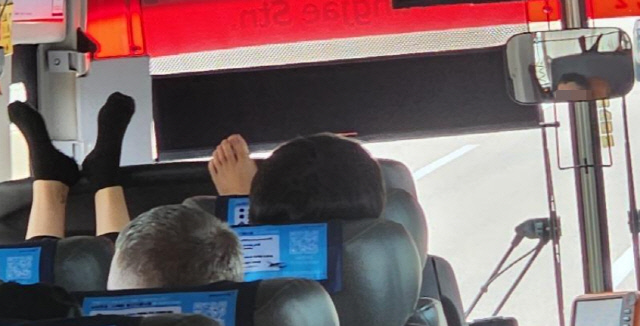 인천공항 리무진 버스 승객 두명이 운전사 좌석 위로 맨발을 올리고 있는 모습[온라인 커뮤니티 '보배드림' 캡쳐]